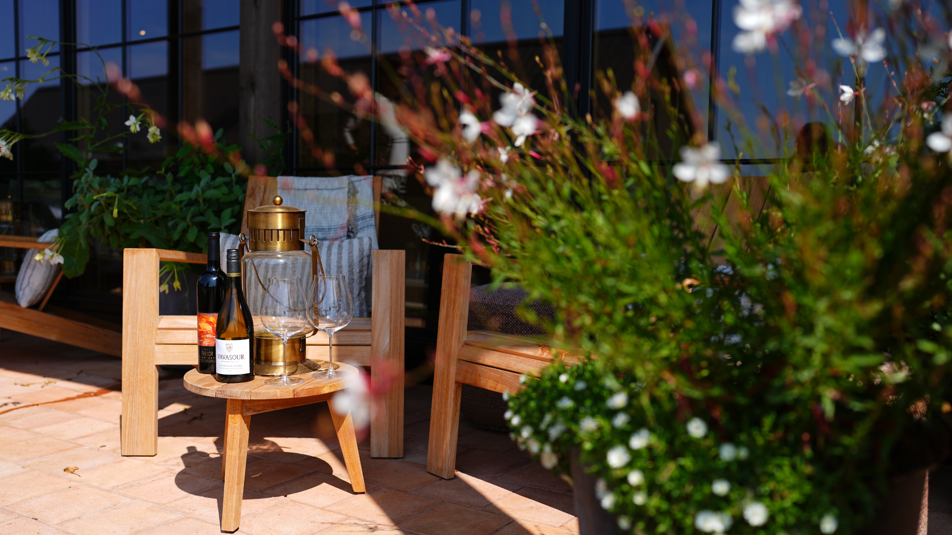 chairs behind a coffee table with two bottles of wine